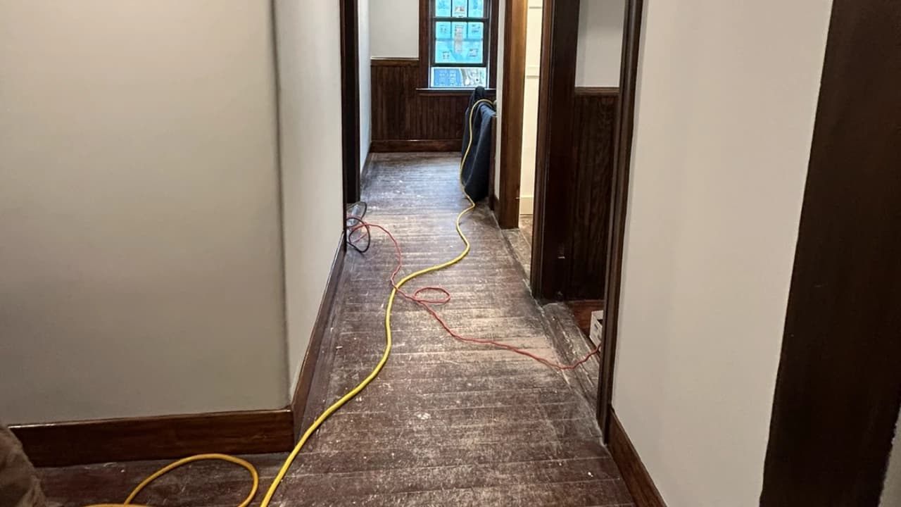 Old hardwood hallway floor before refinishing — pre-sanding stage